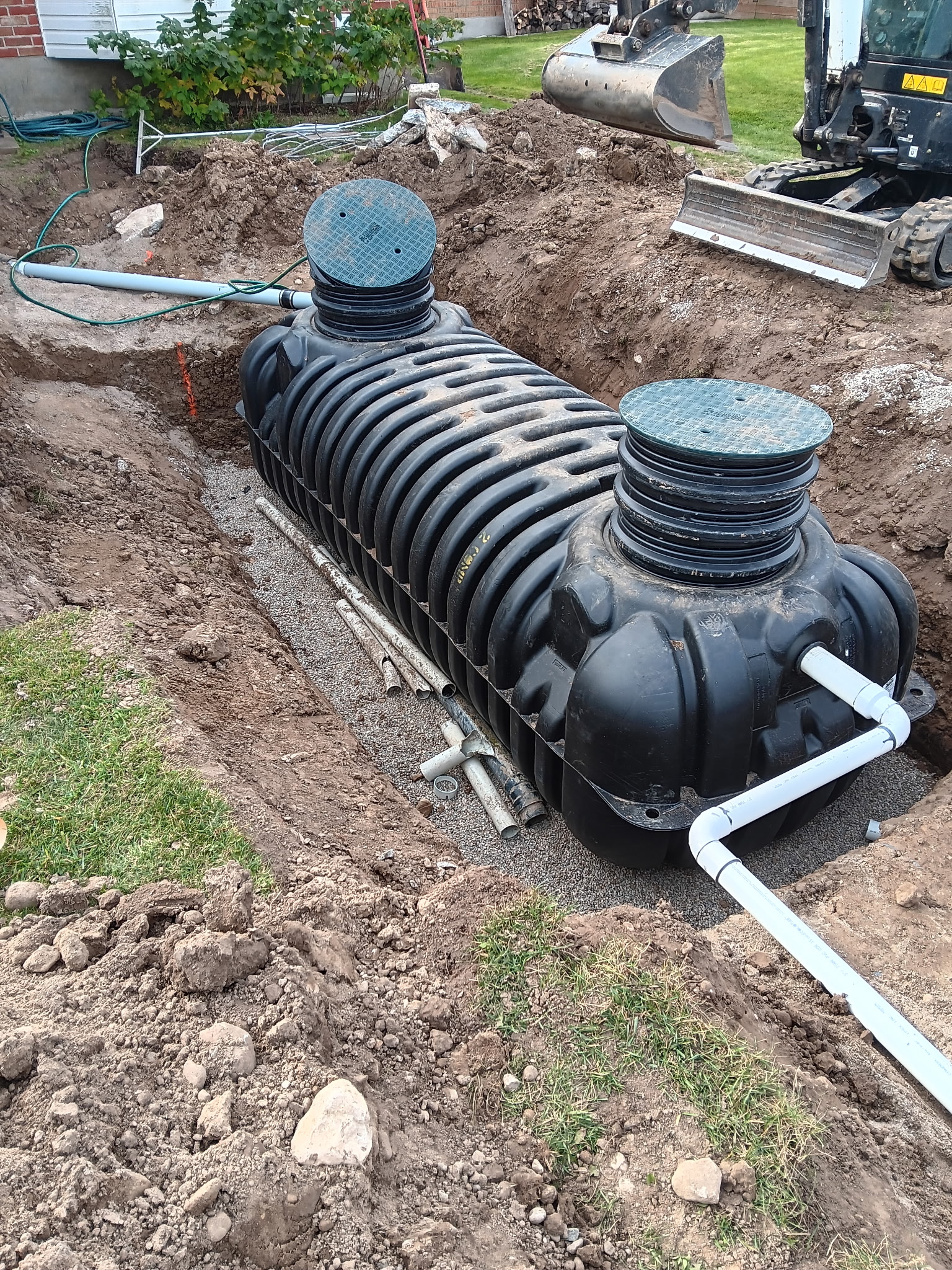 Septic tank installation in progress with access risers visible